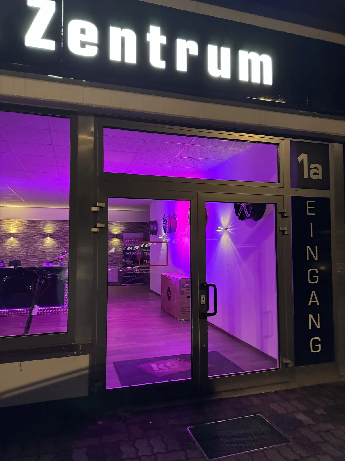 Eingang des KS Autoglas Zentrums Elmshorn am Abend mit beleuchtetem Kundenbereich