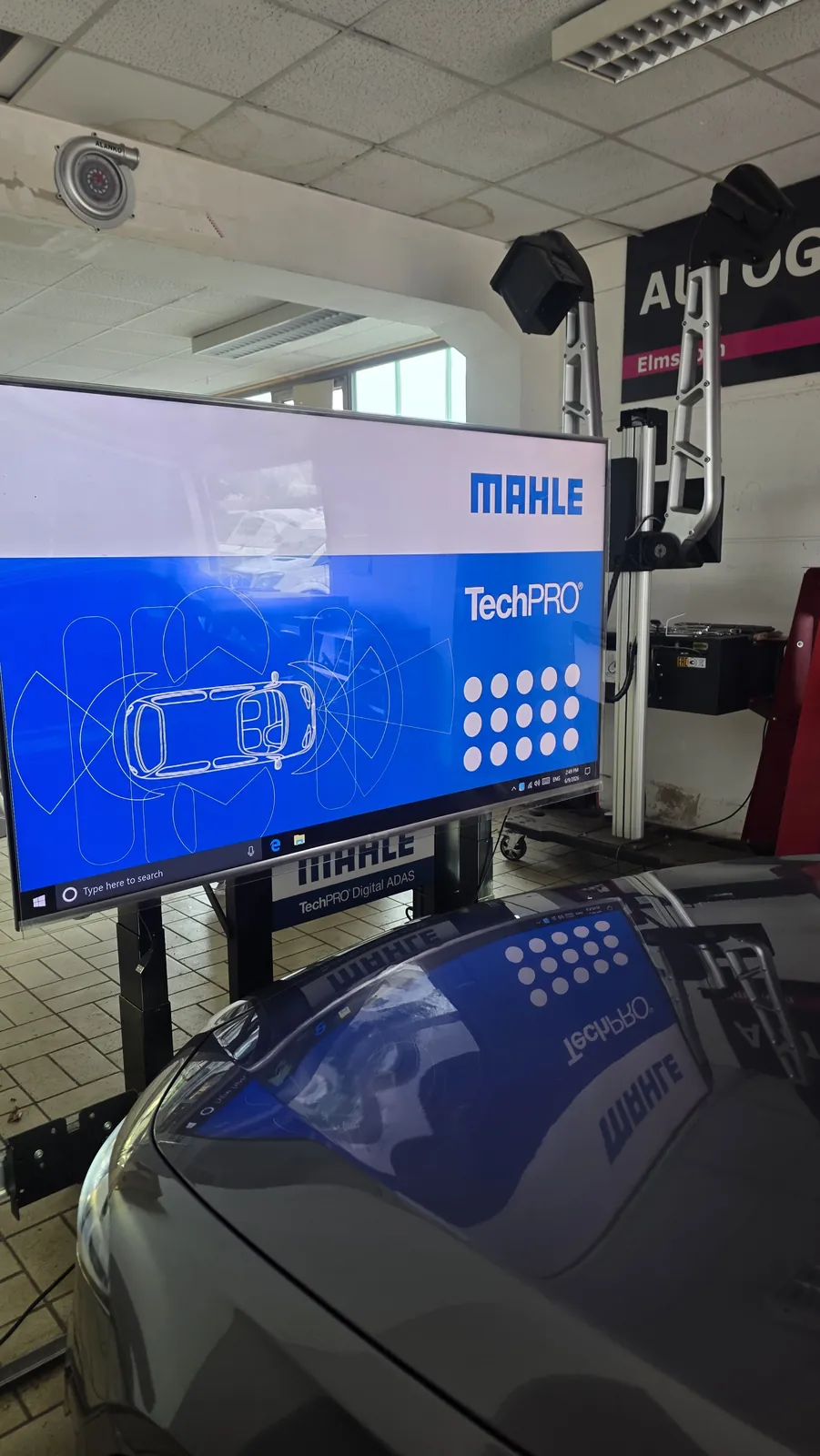 MAHLE-Kalibriertafel vor der Motorhaube eines Pkw in der Werkstatt von KS Autoglas Elmshorn