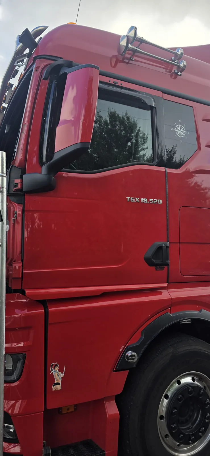 Fahrerhaus eines roten MAN TGX 18.520 am Montagegerüst