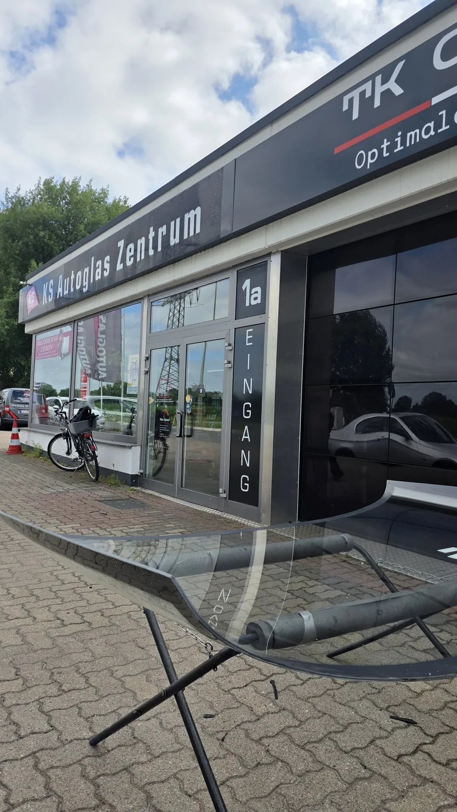 Ausgebaute Wohnmobil-Frontscheibe auf einem Gestell vor dem Eingang des KS Autoglas Zentrums