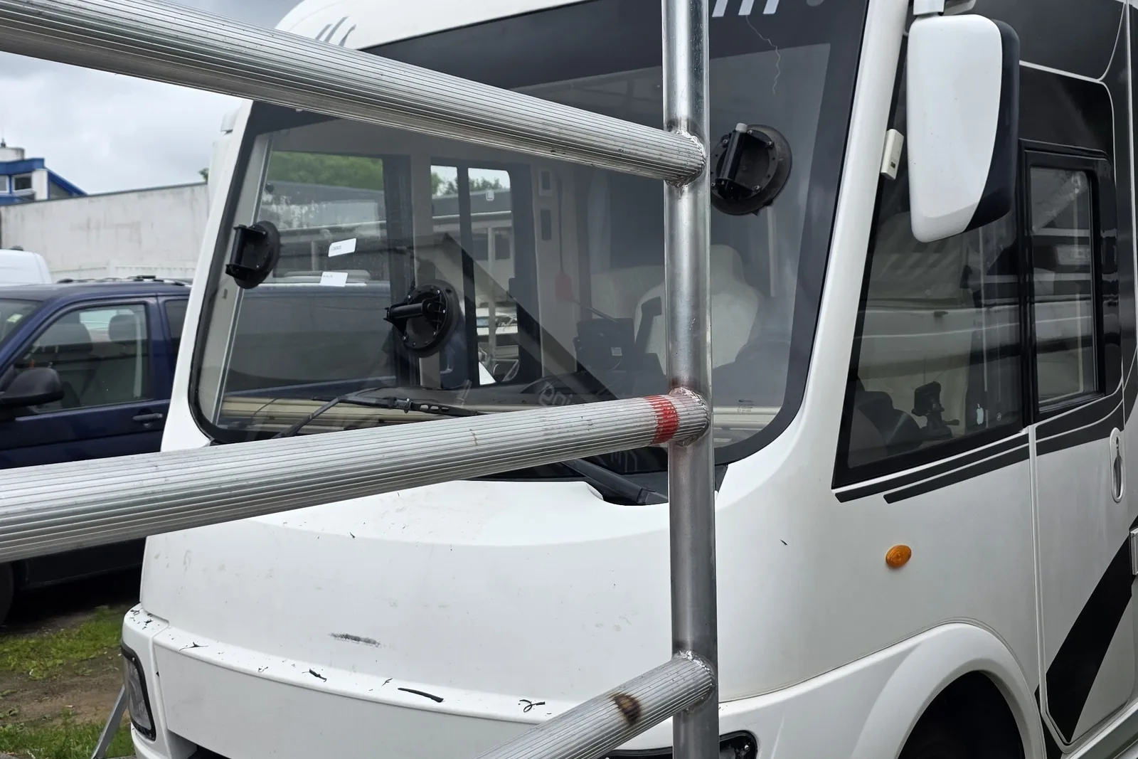 Frontscheibe eines Wohnmobils wird mit Saugnäpfen in den vorbereiteten Rahmen eingesetzt